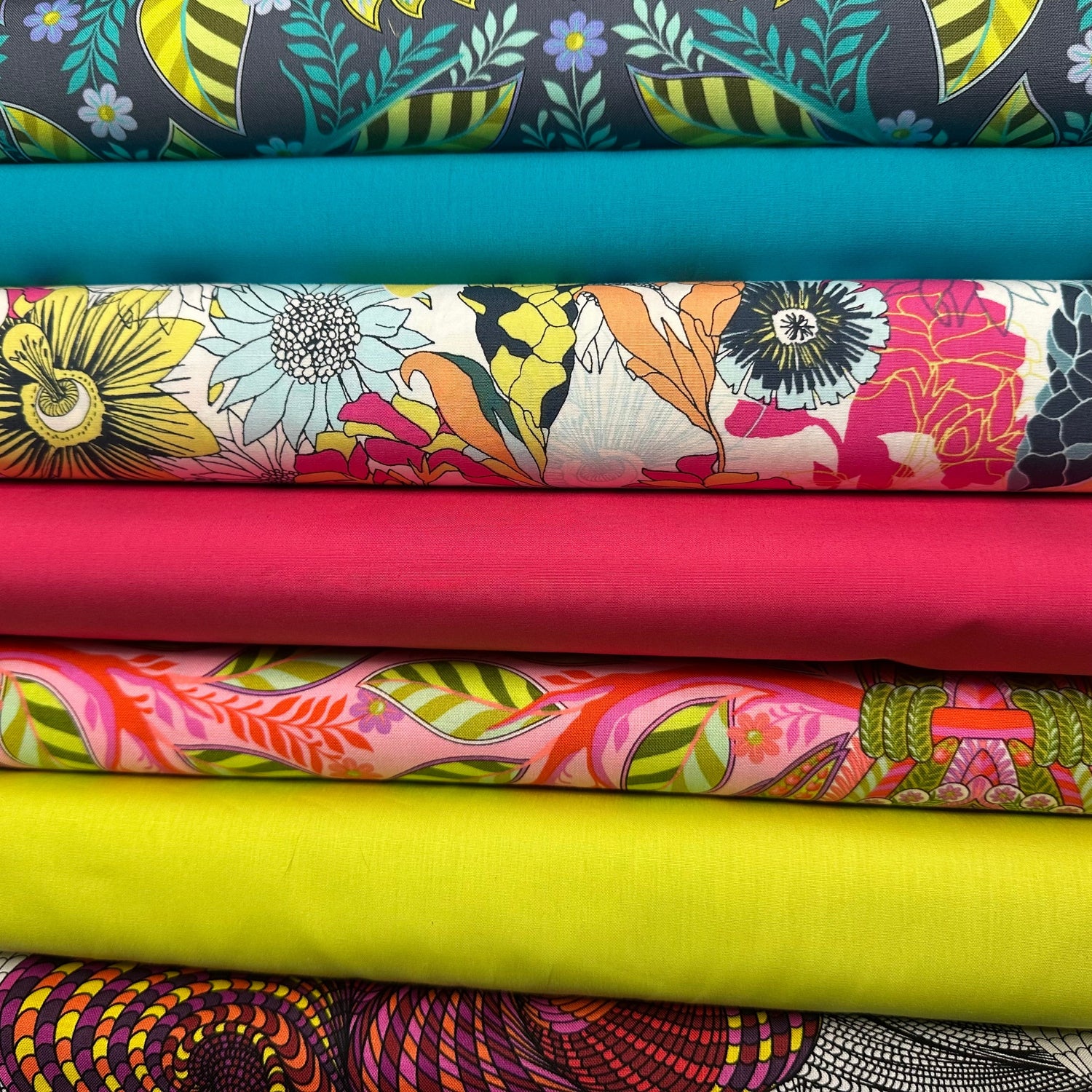 Row of colorful fabric rolls with various patterns-Sew Much