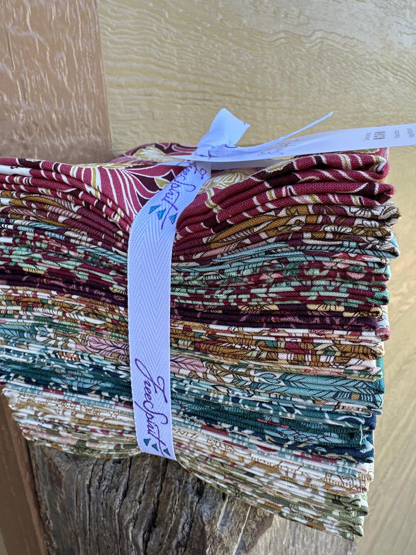 Pack of patterned fabric strips with a visible brand label on a wooden surface